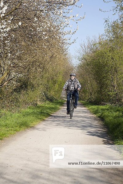Senior with bicycle helmet riding a bike  North Rhine-Westphalia  Germany  Europe