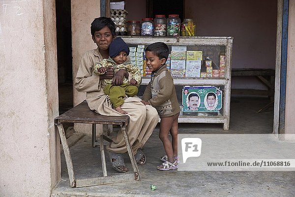 Kinder sitzen vor einem kleinen Laden  Mahey  Pakistan  Asien