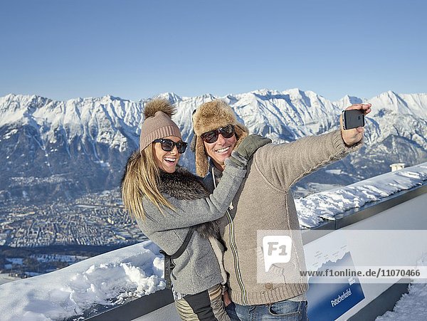 Frau und Mann  Paar fotografiert sich selbst  machen ein Selfie vor Bergkulisse  Patscherkofel  Patsch  Nordkette  Innsbruck  Tirol  Österreich  Europa