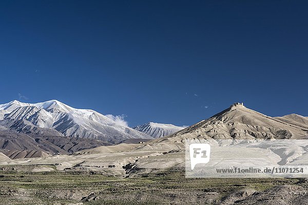 Schneebedeckte Berge und Ruine  Berglandschaft bei Lo Manthang  Königreich Mustang  Upper Mustang  Himalaya  Nepal  Asien