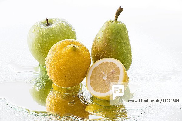 Apfel  Birne und Zitrone mit Wassertropfen spiegeln sich