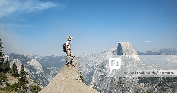 Young man standing on ledge  looking at the Half Dome  view from Glacier Point  Yosemite National Park  California  USA  North America