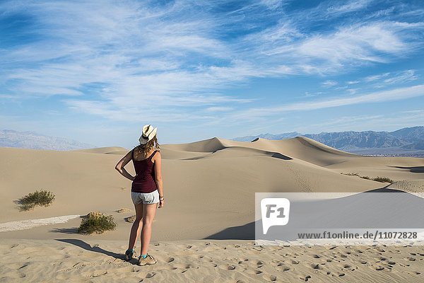 Female tourist overlooking the Mesquite Flat Sand Dunes  sand dunes  foothills of Amargosa Range Mountain Range behind  Death Valley  Death Valley National Park  California  USA  North America