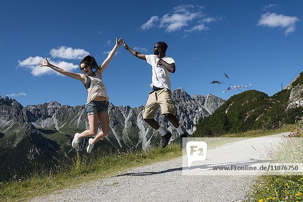 Pärchen springt freudig in die Luft  Bergwanderung  Kalkkögen dahinter  Fulpmes  Stubaital  Tirol  Österreich  Europa