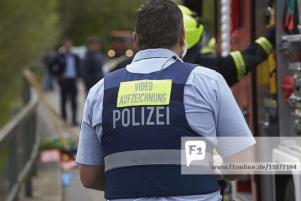 Polizeibeamter mit Rückenschild  Videoaufzeichnung  bei Verkehrsunfall  Deutschland  Europa