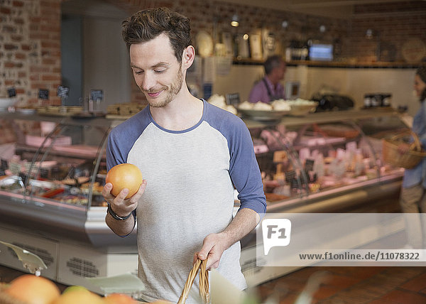 Mann untersucht Grapefruit auf dem Markt