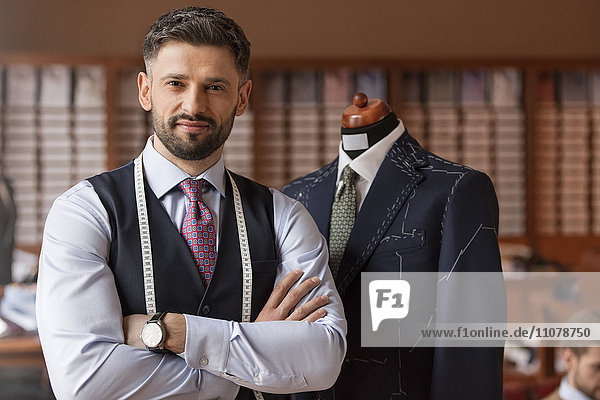 Portrait confident tailor in menswear shop