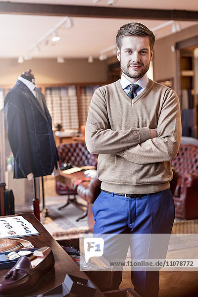 Portrait confident tailor in menswear shop