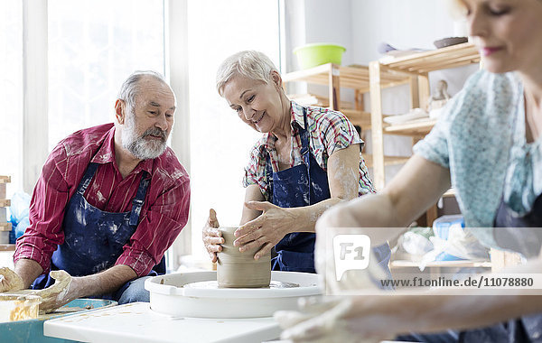 Seniorenpaar mit Töpferscheibe im Atelier