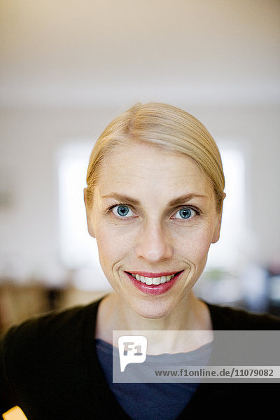 Porträt einer jungen Frau  die lächelt und in die Kamera schaut