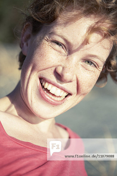 Portrait of freckled young woman laughing