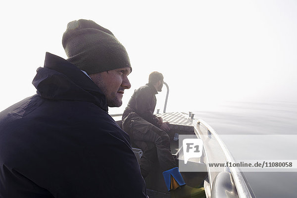Männer auf einem Boot mit Blick auf das Meer