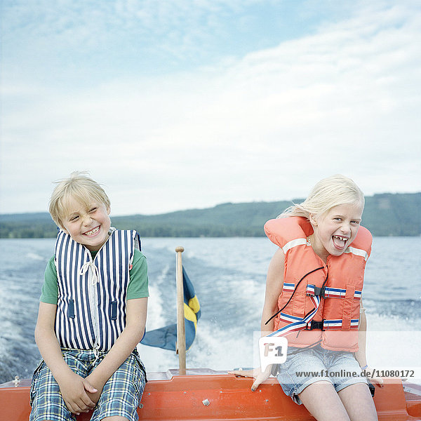 Portrait of two laughing sisters on boat