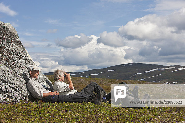 Ältere Männer ruhen sich beim Wandern aus