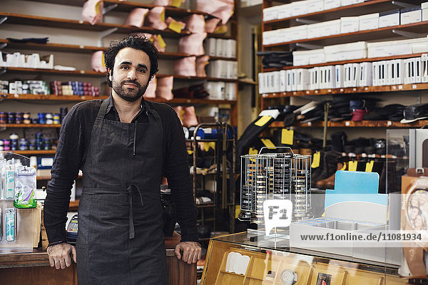 Portrait of man standing in shoe repair store