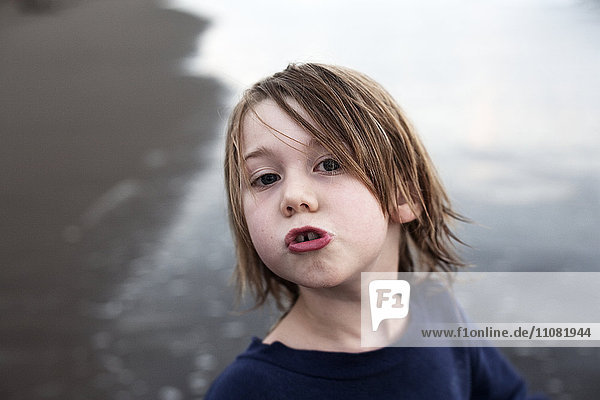 Portrait of boy making face on beach