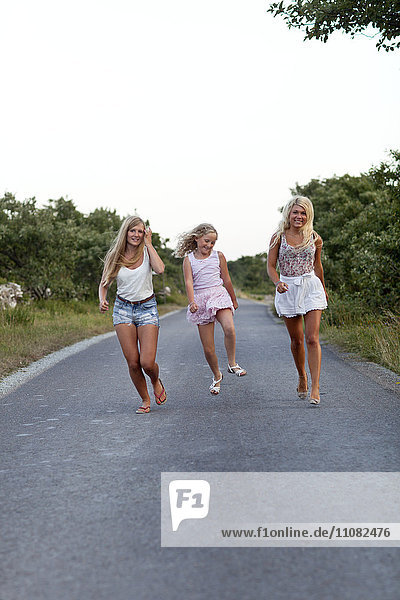Smiling girls walking on road
