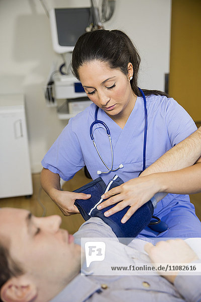 Doctor checking patients blood pressure