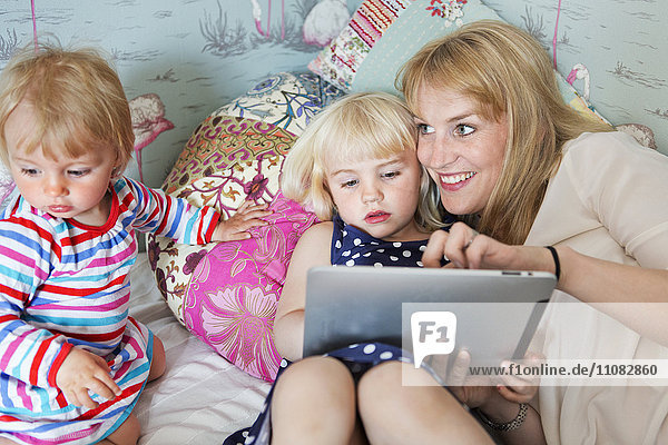 Mother with two children and a digital tablet