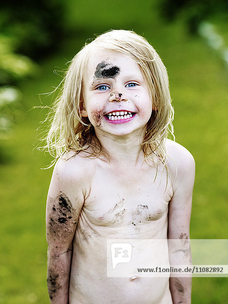 Laughing girl covered with mud