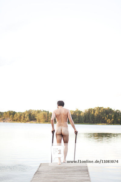 Naked man getting on jetty  Finland