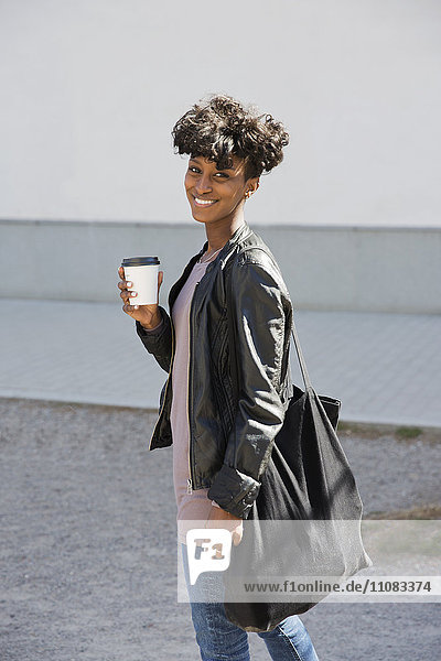 Lächelnde junge Frau mit Kaffee