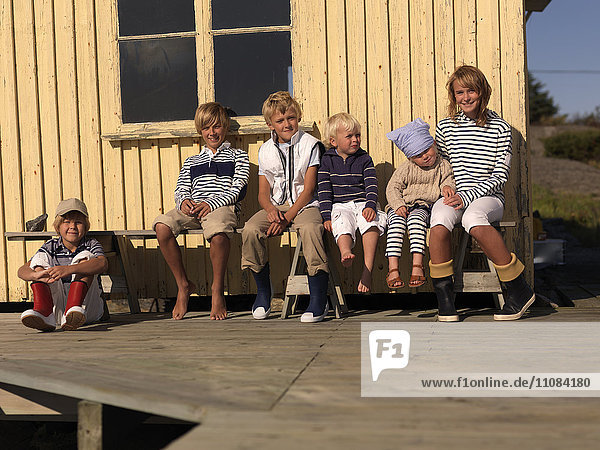 Kinder sitzen vor einem Haus  Vastkusten  Schweden
