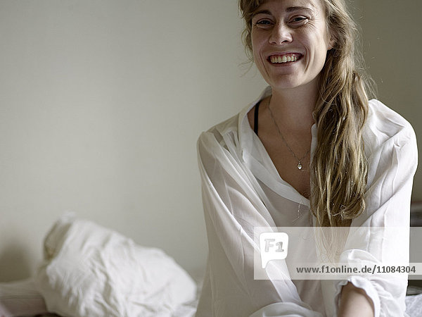 Lächelnde mittelalte Frau auf dem Bett  Stockholm  Schweden