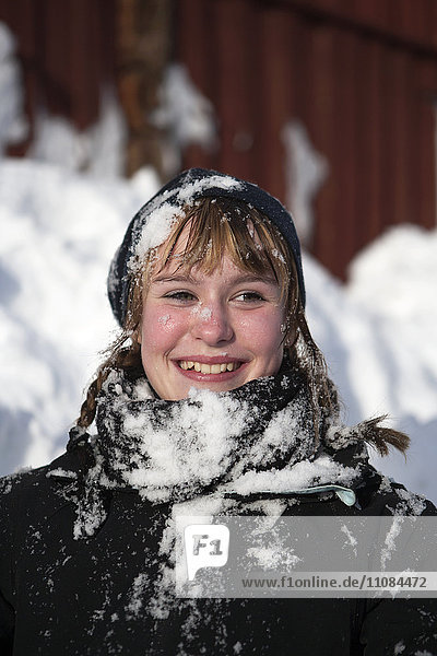 Smiling girl covered in snow