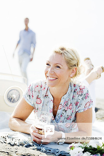 Lächelnde Frau auf dem Sand liegend