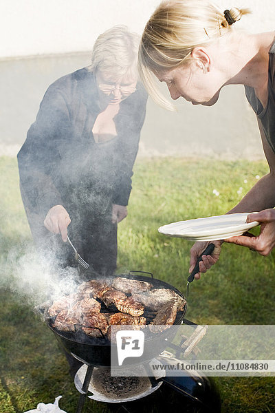 Two women making dinner outdoors  Gotland  Sweden.