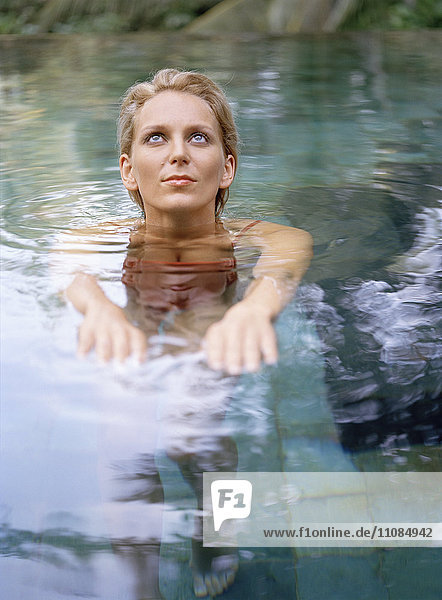 Eine Frau steht in einem Schwimmbad  Bali.