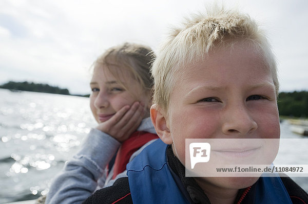 A boy and a girl sitting in a boat  Sweden.
