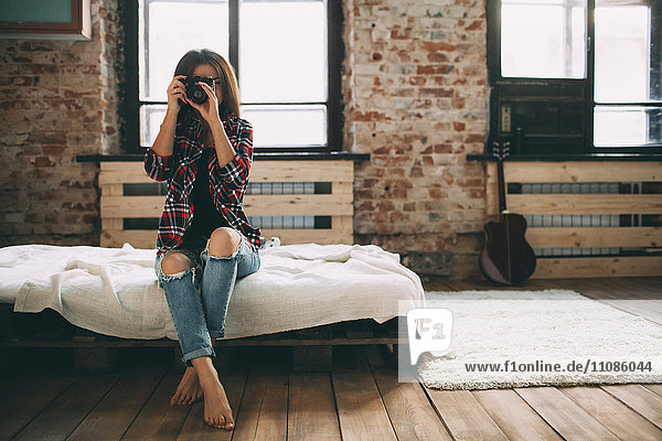 Volle Länge der Frau fotografiert durch SLR-Kamera im Schlafzimmer zu Hause