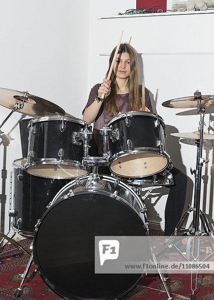 Junge Frau spielt Schlagzeug