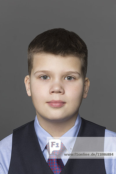 Portrait of boy against gray background