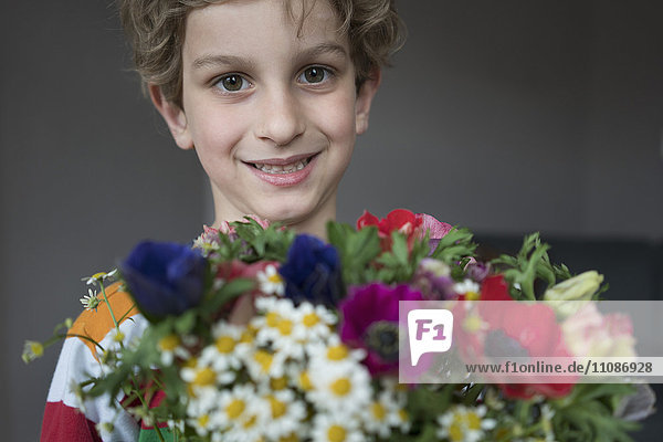 Nahaufnahme des lächelnden Jungen mit Blumenstrauß