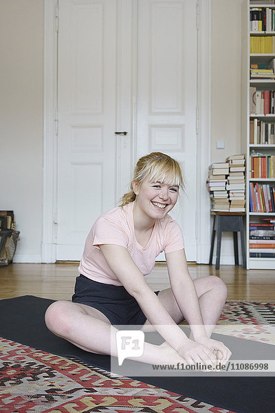 Portrait of smiling woman exercising in living room at home