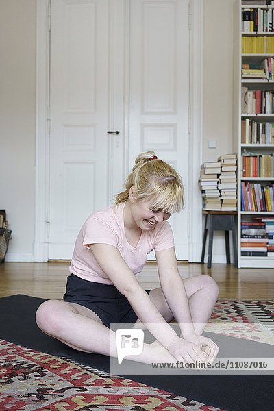 Happy woman exercising on floor at home