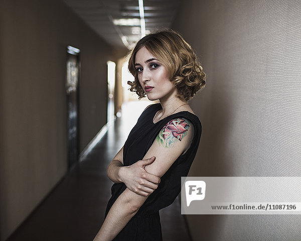 Portrait of confident young woman standing in corridor
