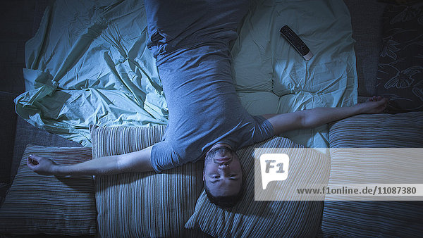 Directly above portrait shot of man lying on sofa at home