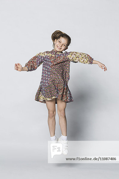 Portrait of cheerful girl jumping against white background