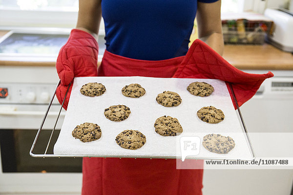 Woman showing a tray of freshly baked cookies