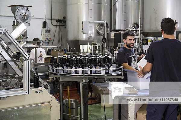 Men working in beer bottling plant