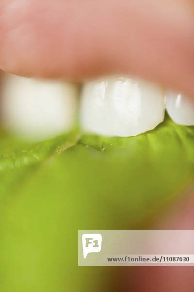 Extreme close-up of woman eating leafy vegetable