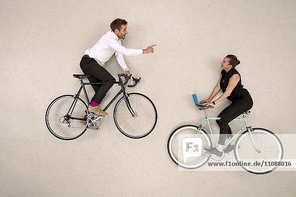 Two business colleagues biking and communicating