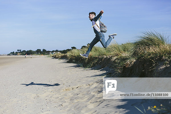 Young man jumping in the air on the beach