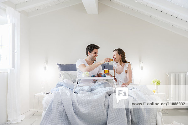 Couple in bed with breakfast tray