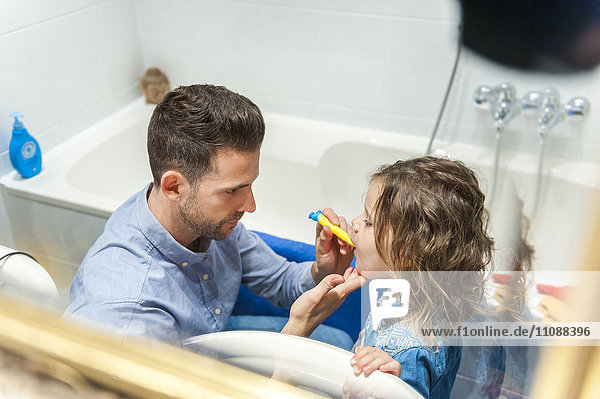 Vater putzt Mädchenzähne
