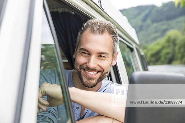 Porträt eines lächelnden Mannes im Van